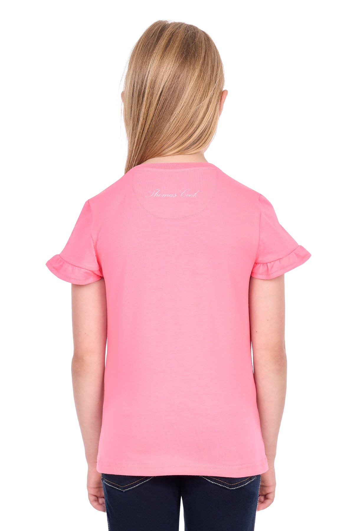 A young girl with blonde hair is shown from the back, wearing a bright pink short-sleeve t-shirt with ruffled cuffs and a small white script logo on the upper back, paired with dark blue jeans against a white background.