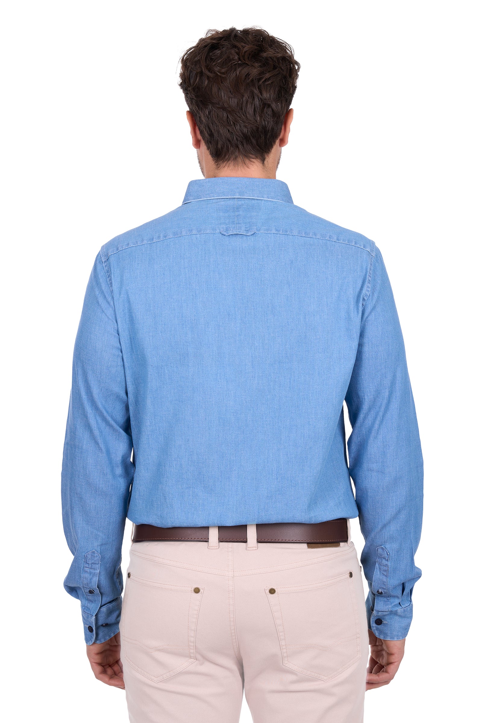 Man wearing a blue denim shirt and beige pants on a white background