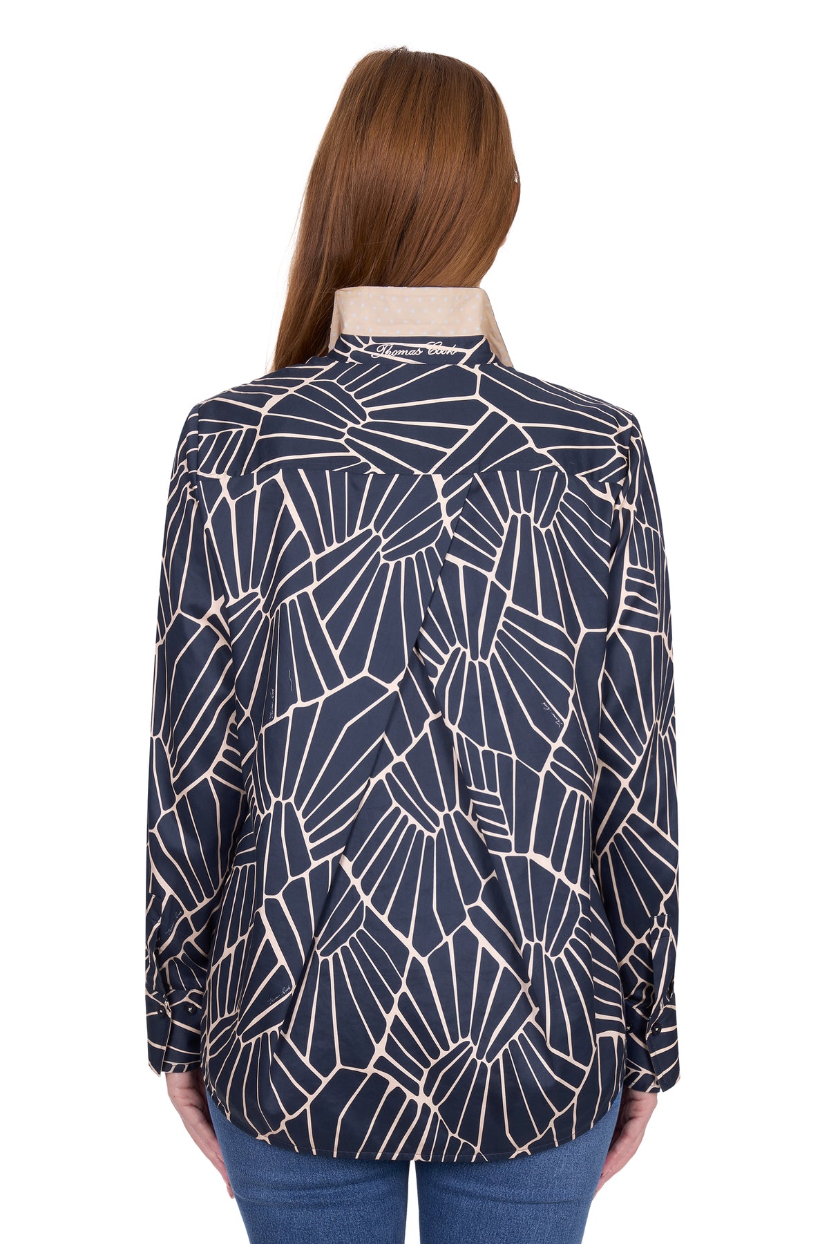 Woman wearing a navy blue geometric patterned shirt on a white background