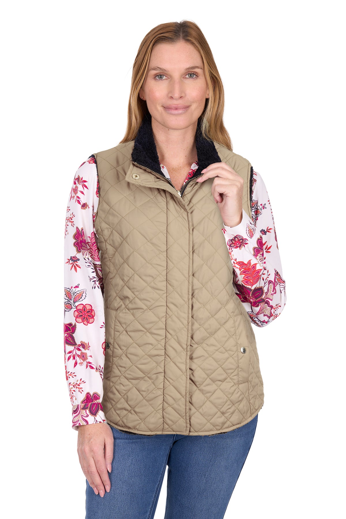 Woman wearing a beige quilted vest over a floral shirt on a white background