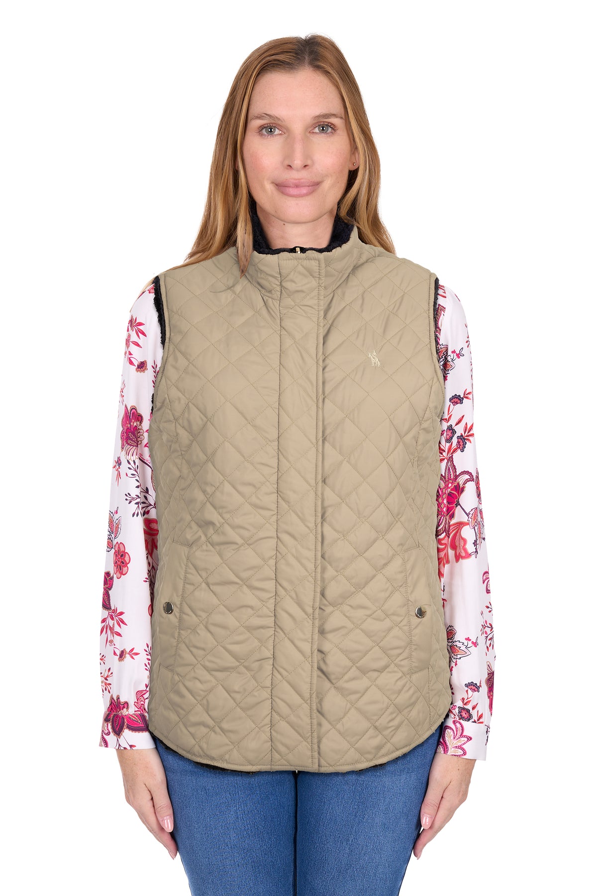 Woman wearing a beige quilted vest over a floral shirt on a white background