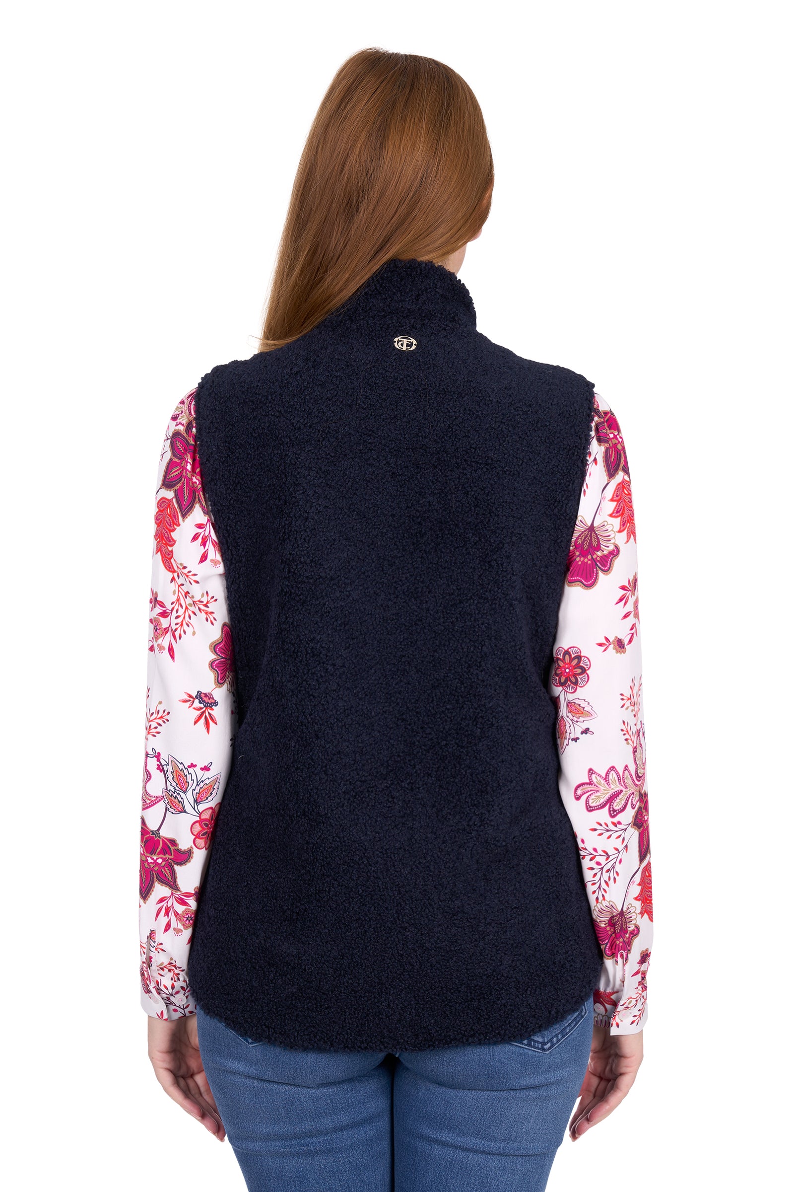 Person wearing a navy vest over a floral shirt on a white background