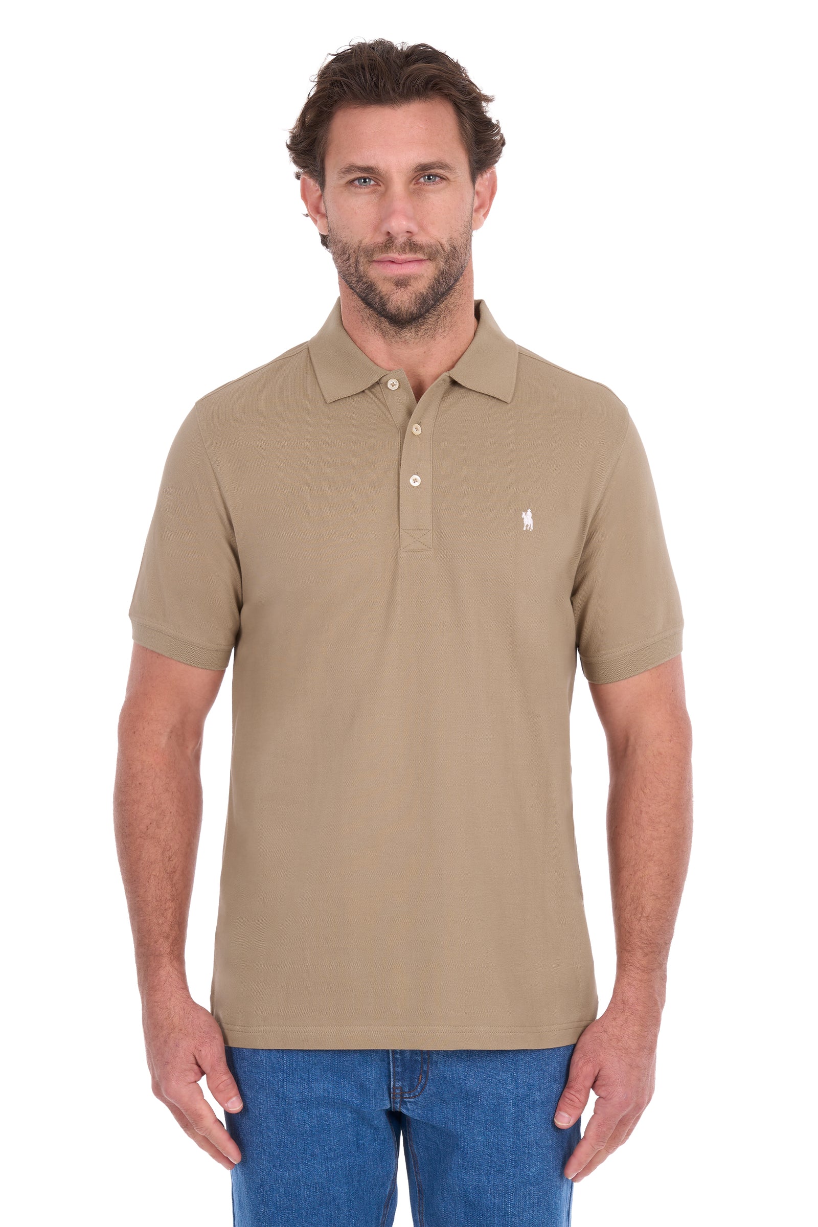 A man wearing a beige short-sleeve polo shirt with a small white embroidered logo on the chest, paired with blue jeans, against a plain white background.