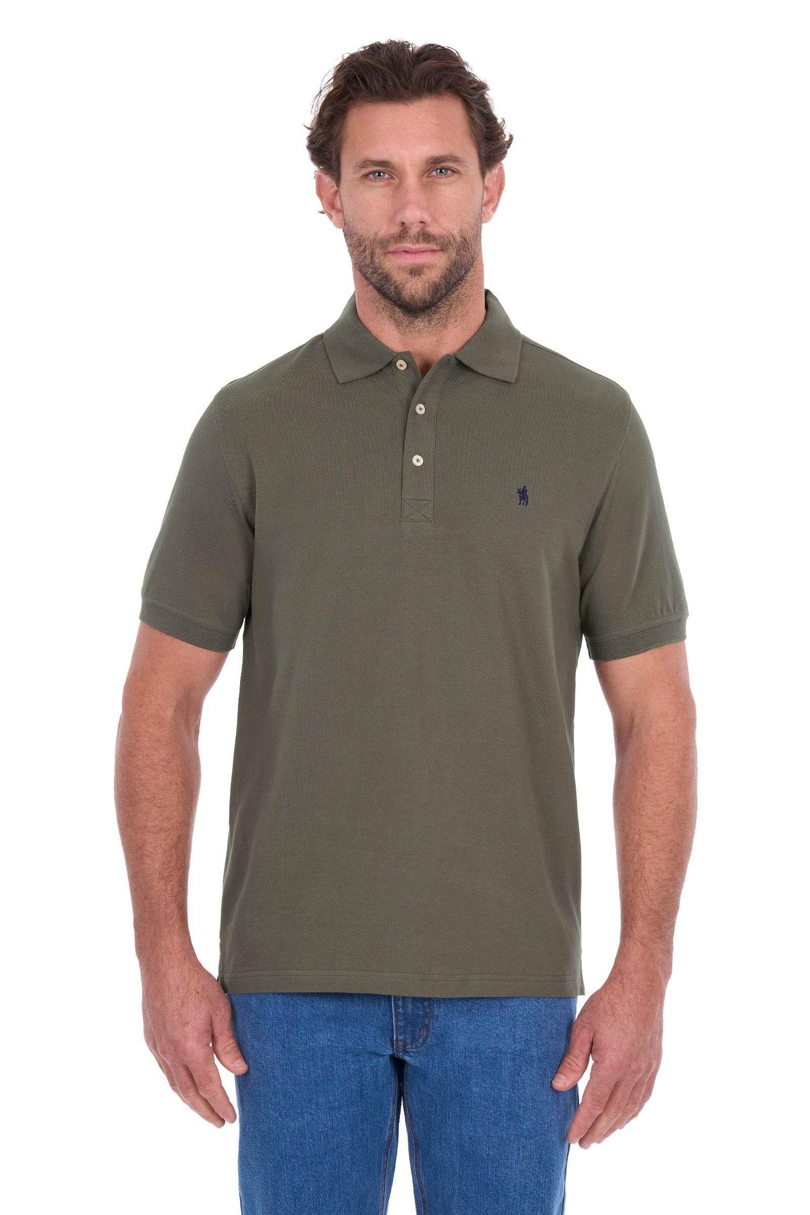 A man wearing an olive green short-sleeve polo shirt with a small navy embroidered logo on the left chest, paired with blue jeans, against a plain white background.