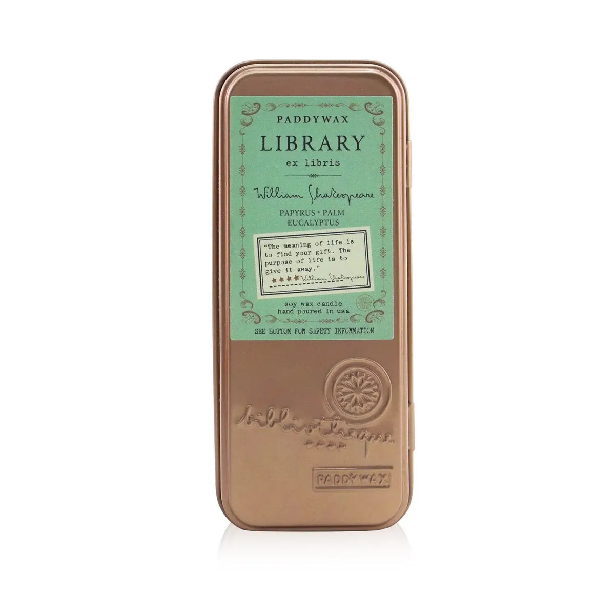 A travel-sized tin candle with a label that says &#39;Shakespeare Library&#39; and lists the scents of papyrus, palm, and eucalyptus. The candle is in a bronze-colored tin with decorative text.