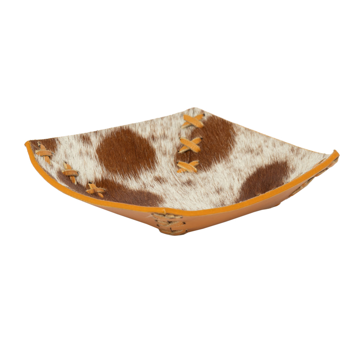 Decorative bowl with cow print and orange accents on a white background
