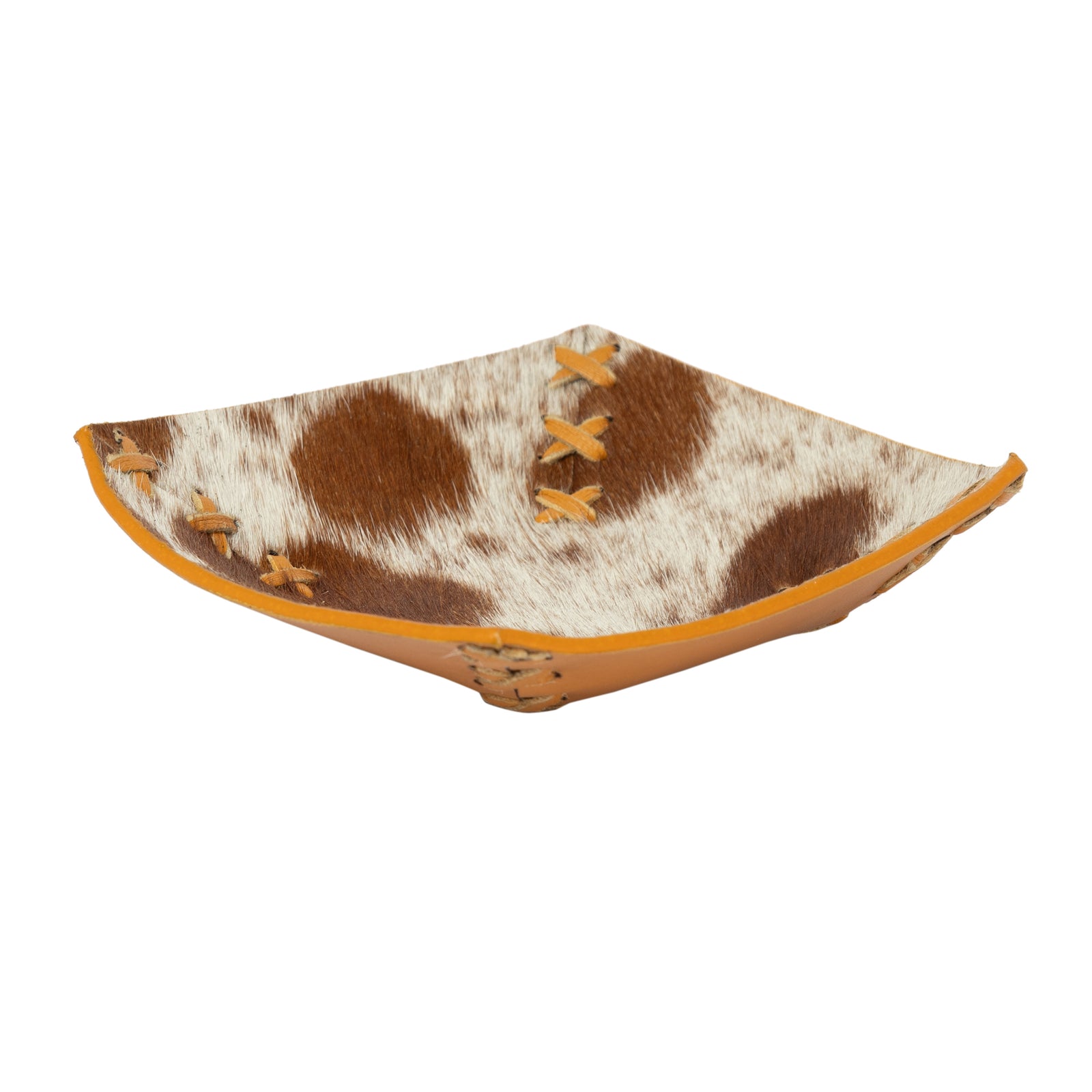 Decorative bowl with cow print and orange accents on a white background