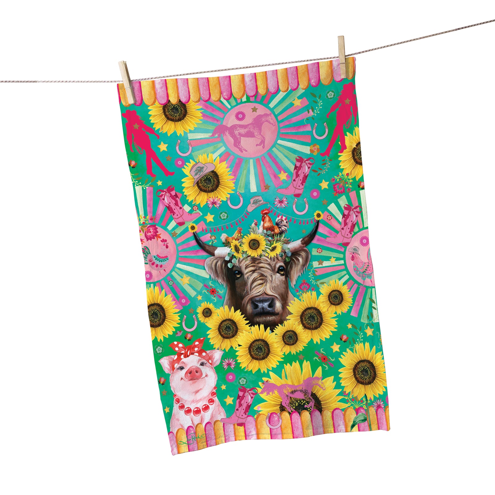 Lisa Pollock Carnival Cow Tea Towel. Colorful towel with animal and sunflower design hanging on a line.