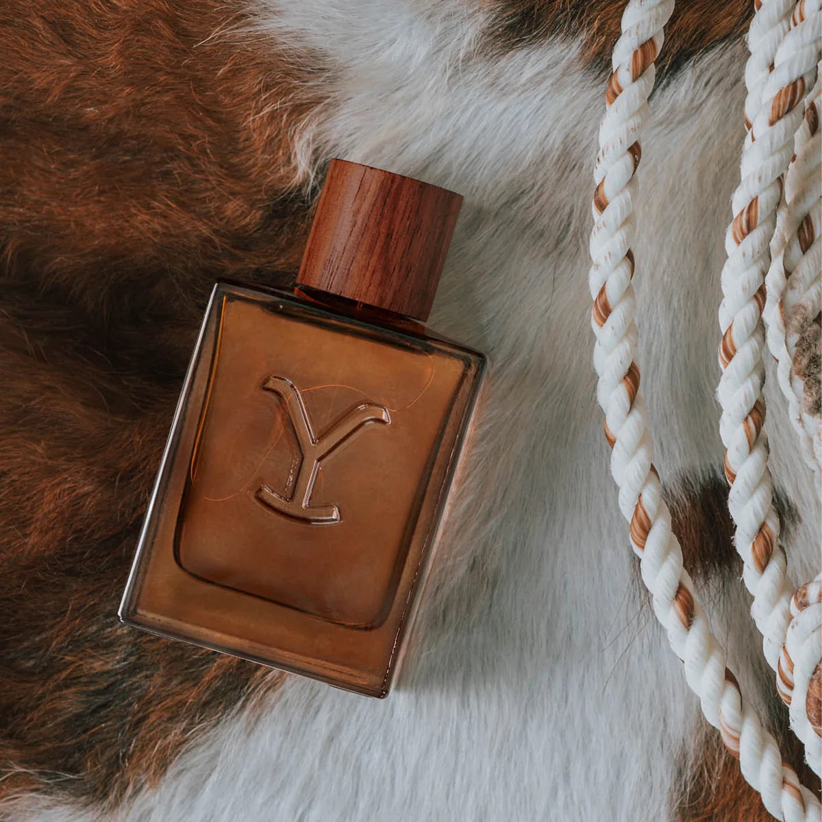 Brown leather-textured bottle with a wooden cap on a fur surface