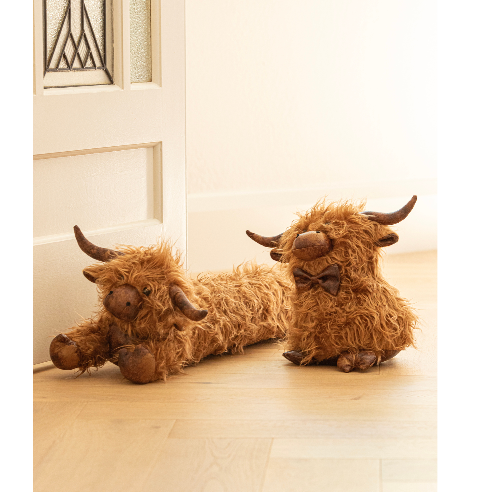 Two fluffy brown yak-shaped slippers on a wooden floor.