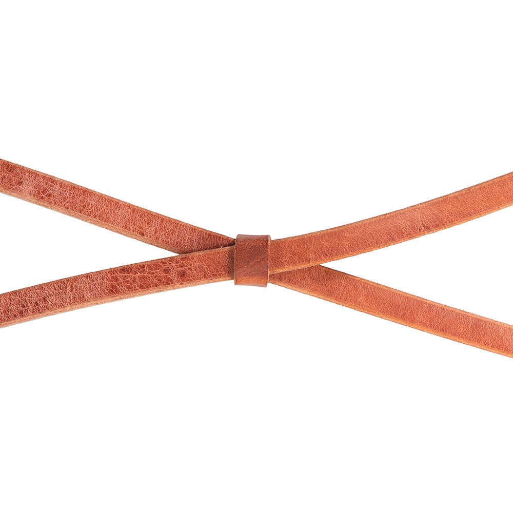 A close-up of a textured leather strap, likely a belt or strap accessory, tied in an X-shape with a small loop closure, on a solid white background.