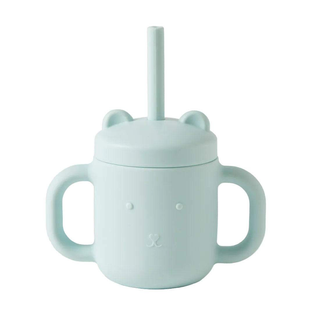 Light blue children's cup with handle and straw lid on a light gray background