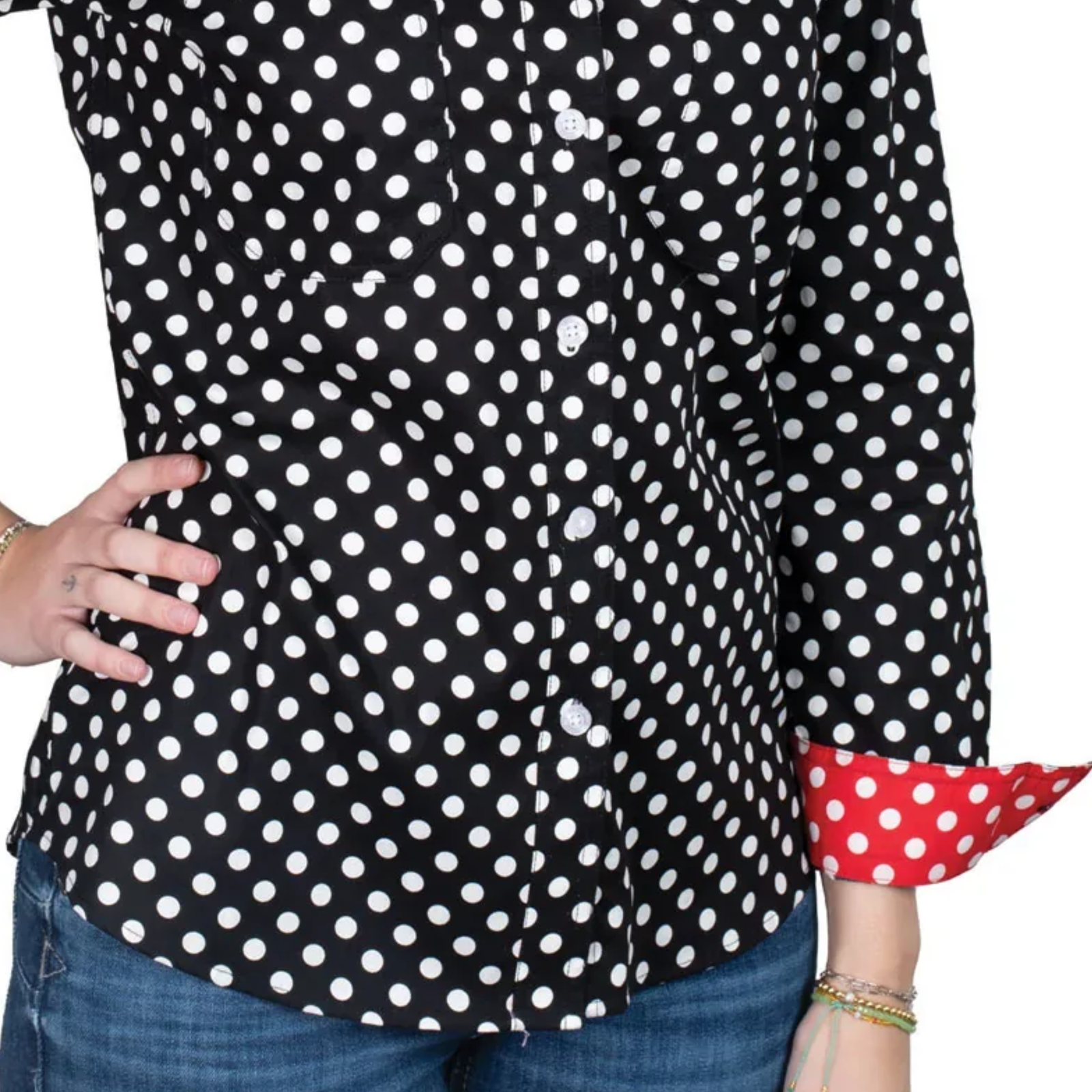 Black polka dot shirt with red and white cuffs worn by a person.