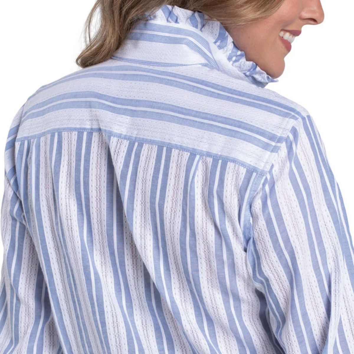 Close-up of a person wearing a blue and white striped shirt with a blurred background