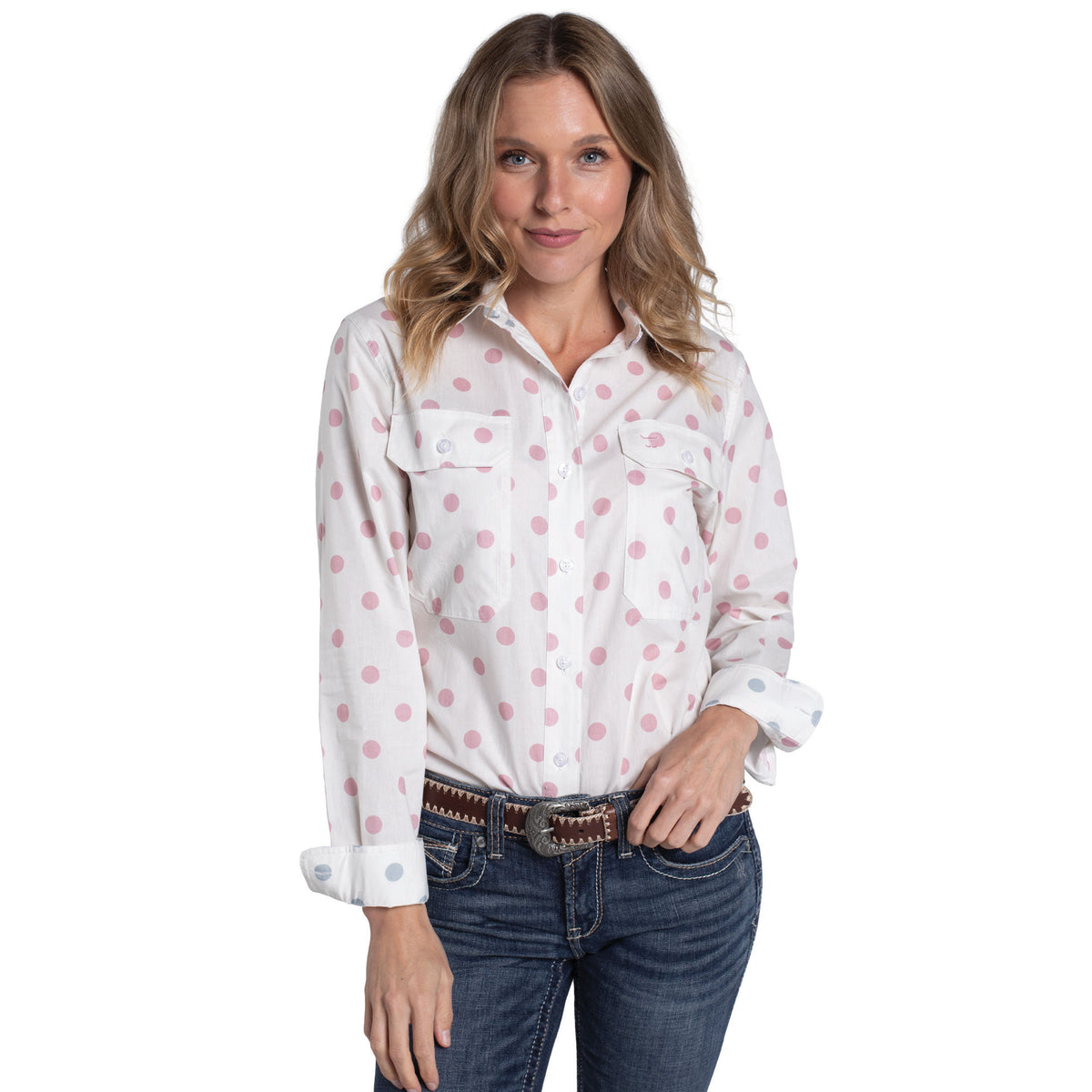 Woman wearing a white shirt with pink polka dots and blue jeans on a white background
