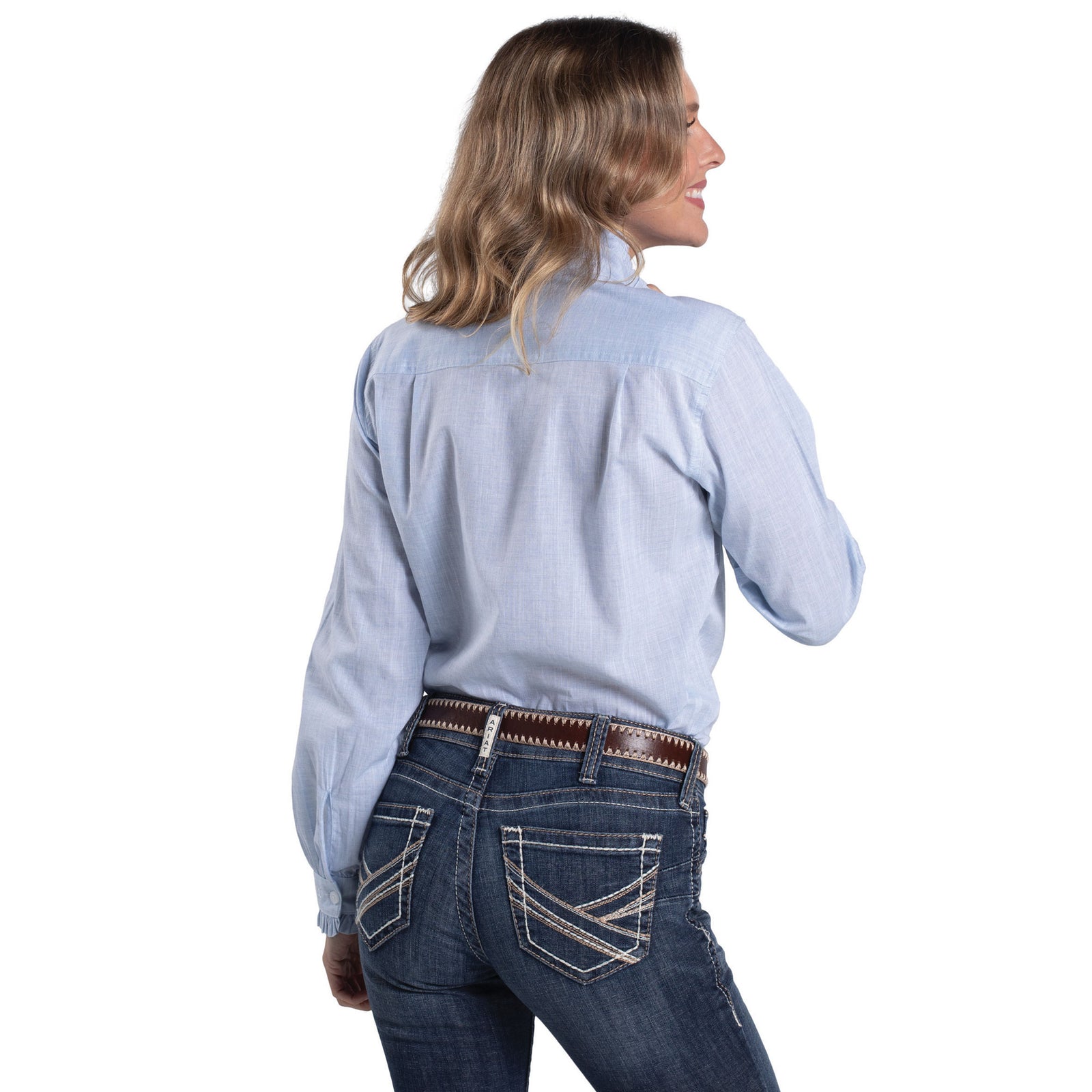 Woman wearing a light blue shirt and dark jeans on a white background