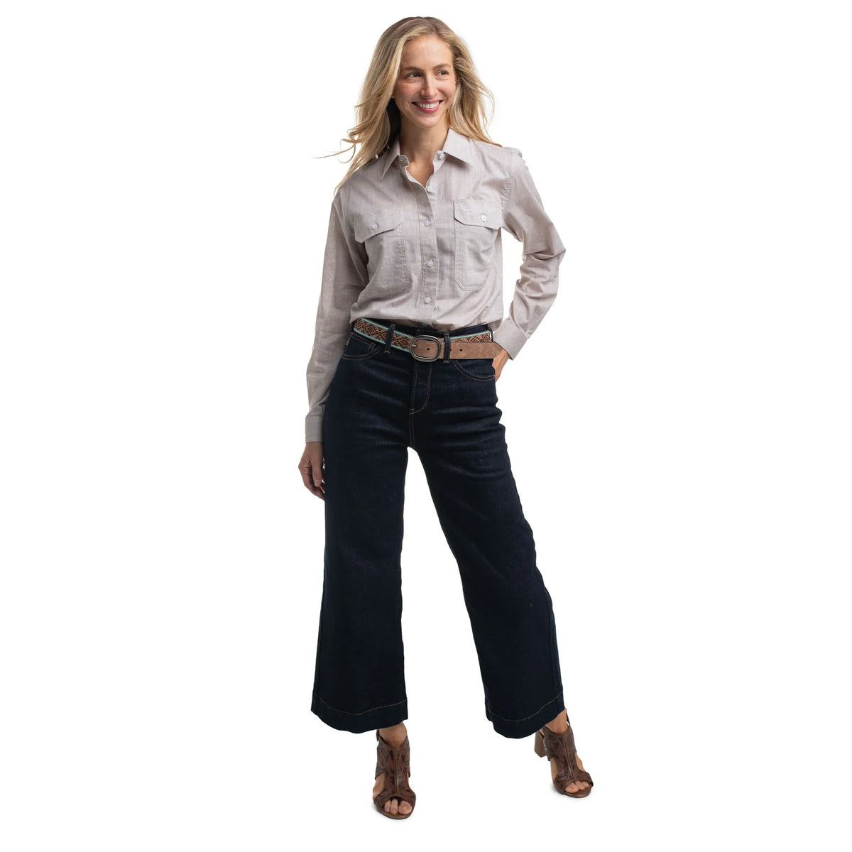 Woman wearing a light-colored shirt and dark jeans on a white background