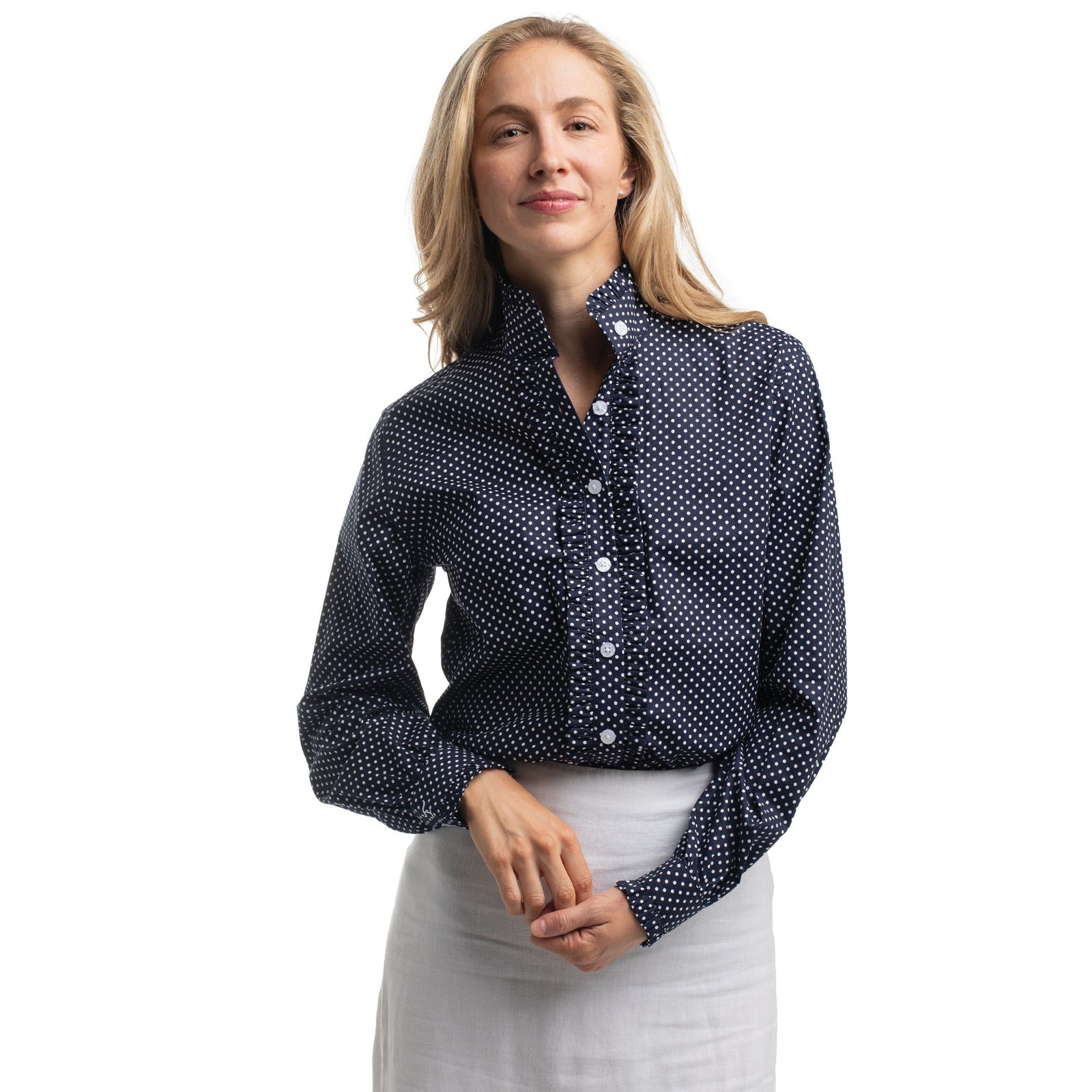 Woman wearing a navy blue polka dot shirt on a white background