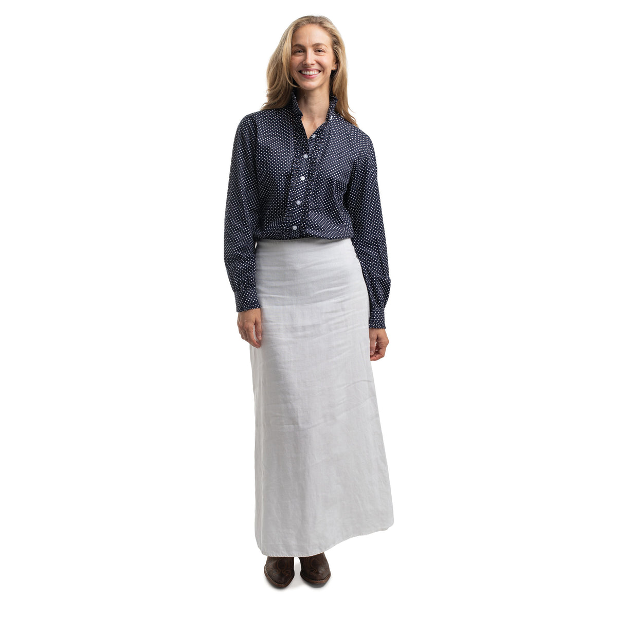 Woman wearing a dark blue patterned shirt and light gray skirt on a white background