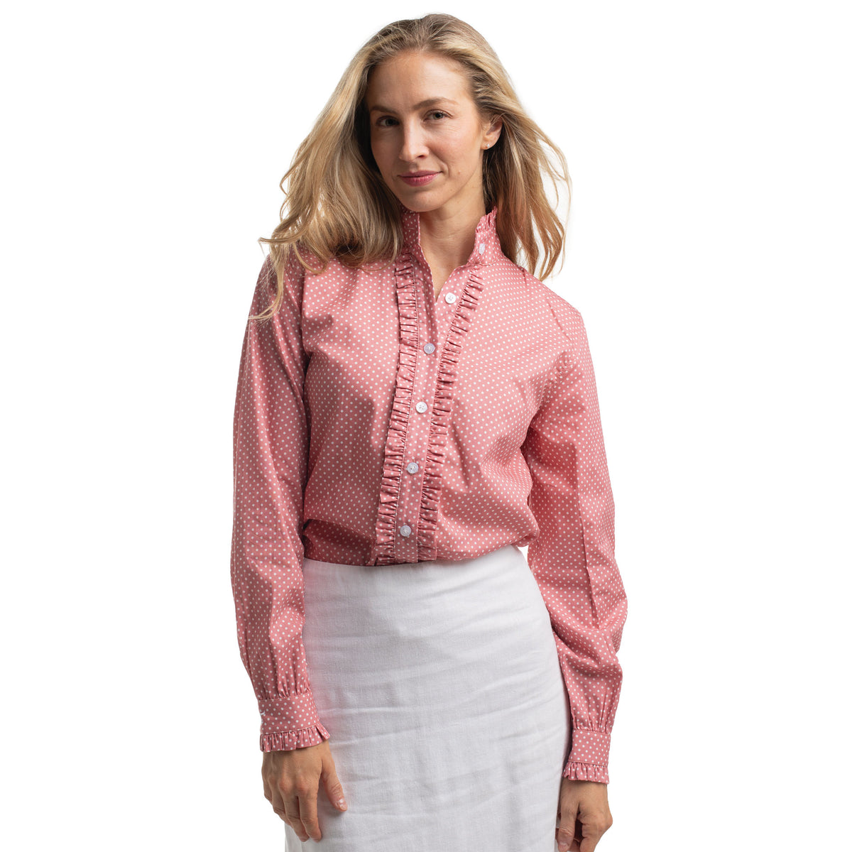 Woman wearing a pink blouse with ruffled details on a white background
