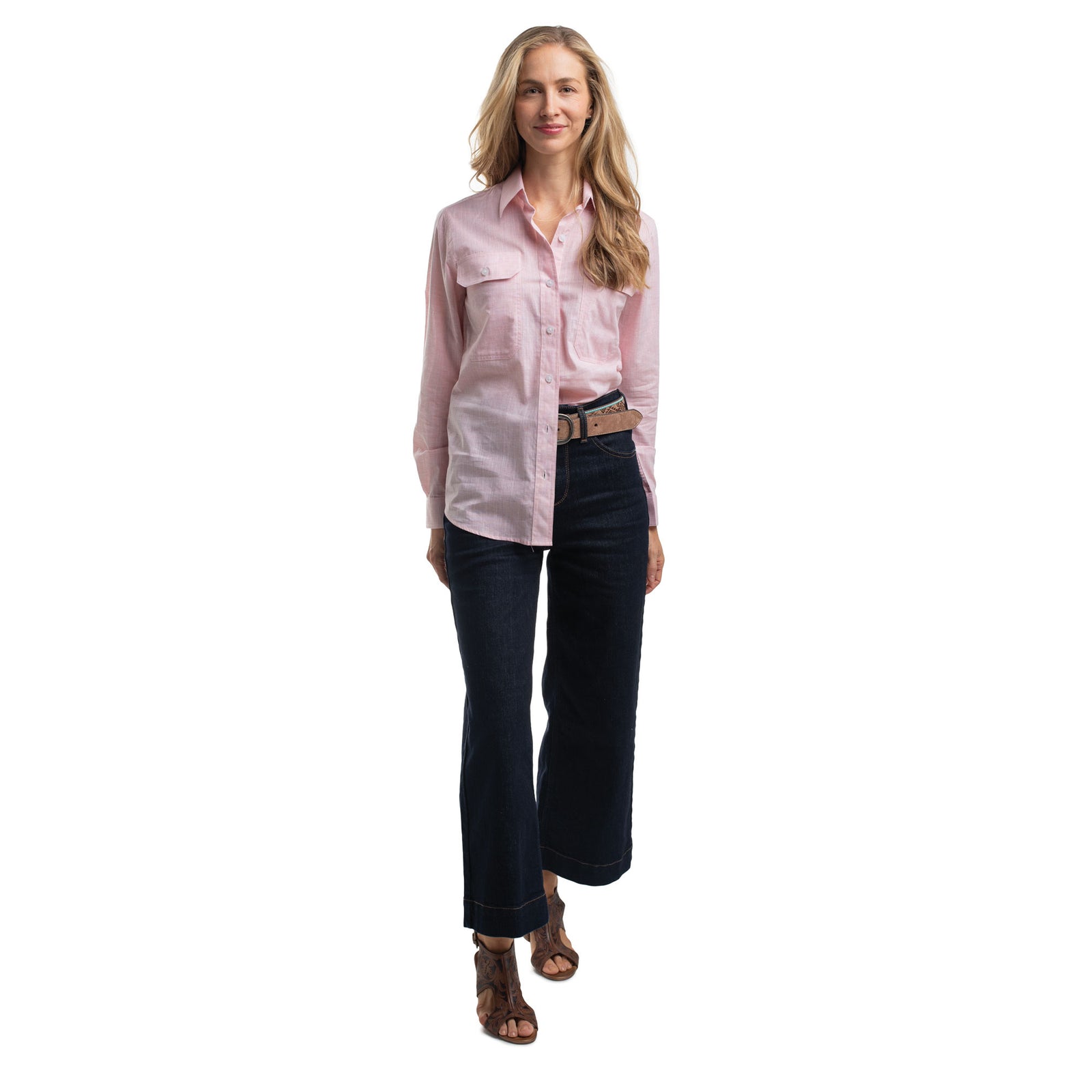 Woman wearing a pink shirt and dark jeans on a white background