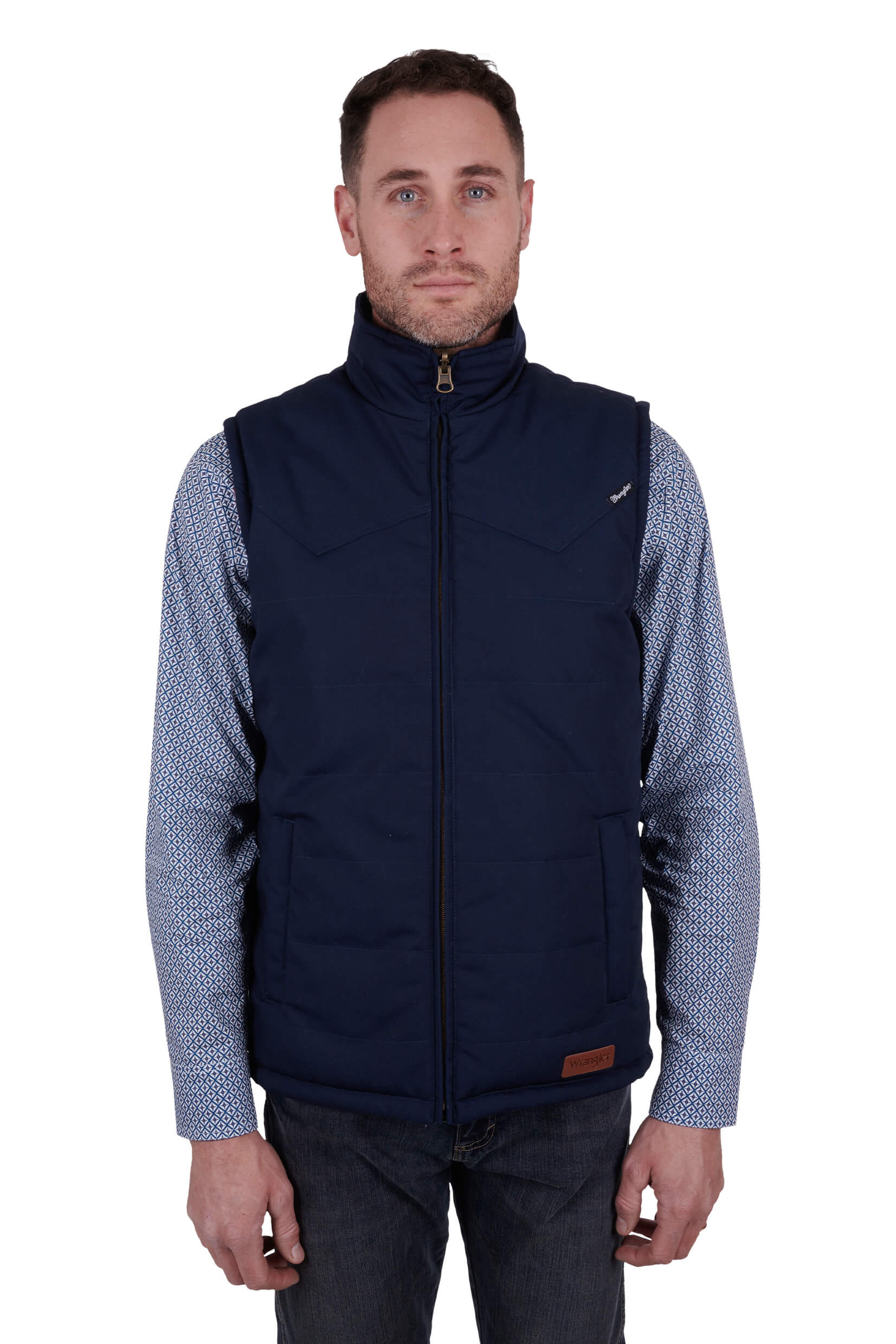 A man wearing a navy blue Wrangler reversible vest with a check pattern on the inside and a visible brand logo on the chest.
