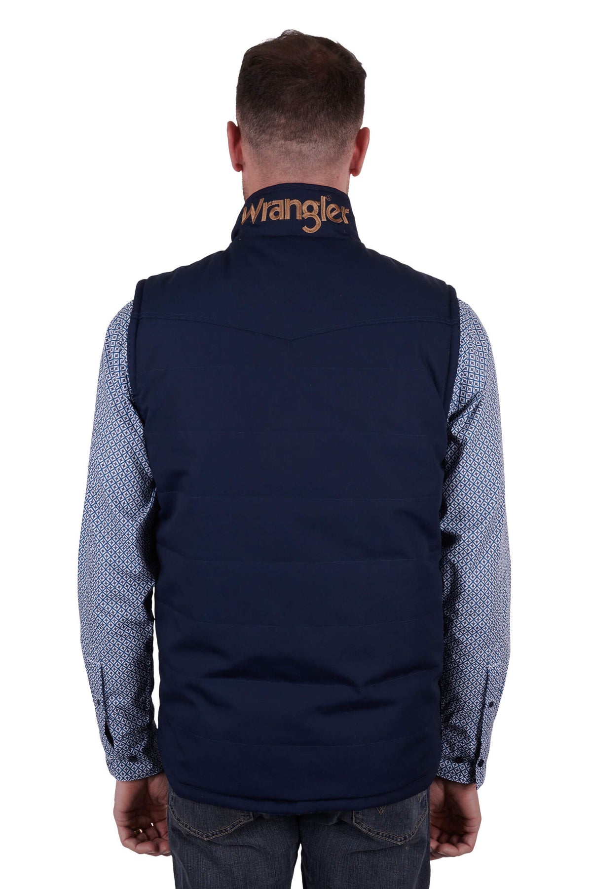 A man wearing a navy blue Wrangler reversible vest with a check pattern on the inside and a visible brand logo on the chest.