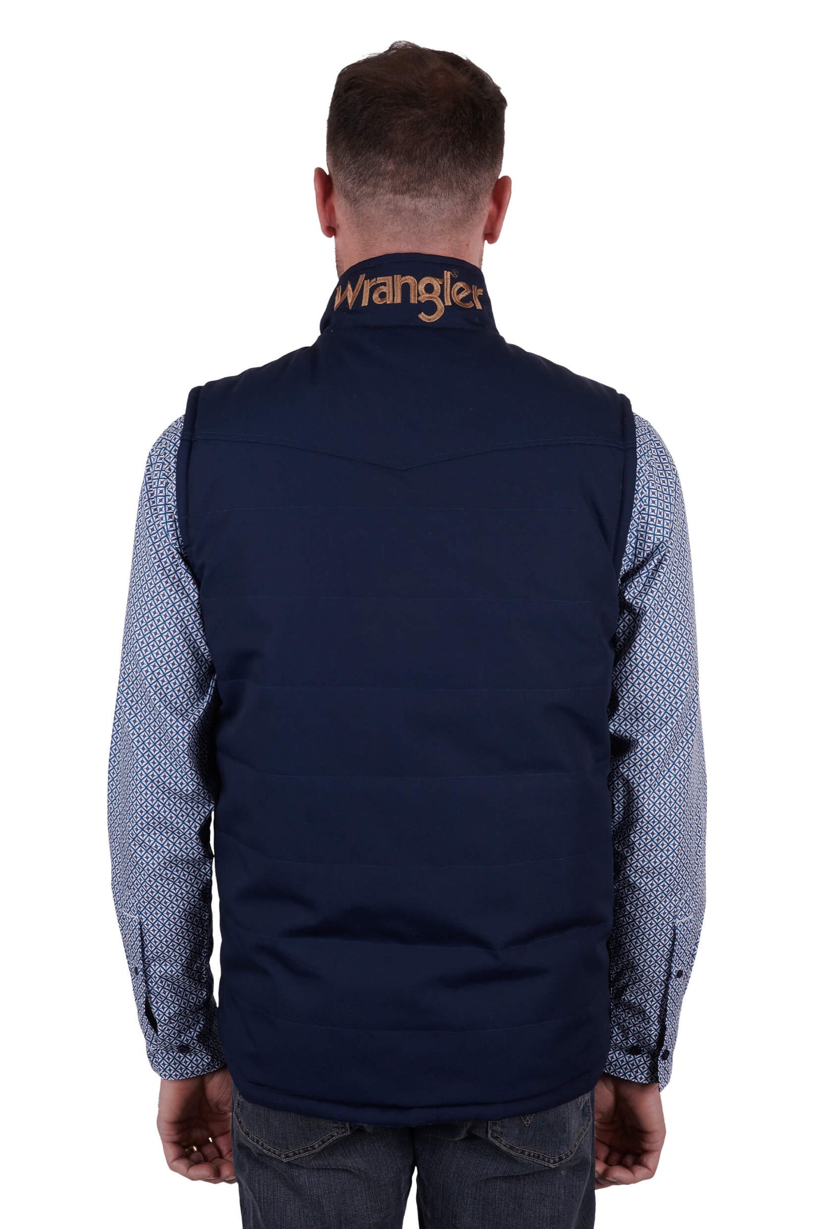 A man wearing a navy blue Wrangler reversible vest with a check pattern on the inside and a visible brand logo on the chest.