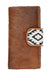 A brown bifold Wrangler Women's Ellery Western Wallet with a hair-on cowhide front panel and an Aztec printed canvas tab closure.