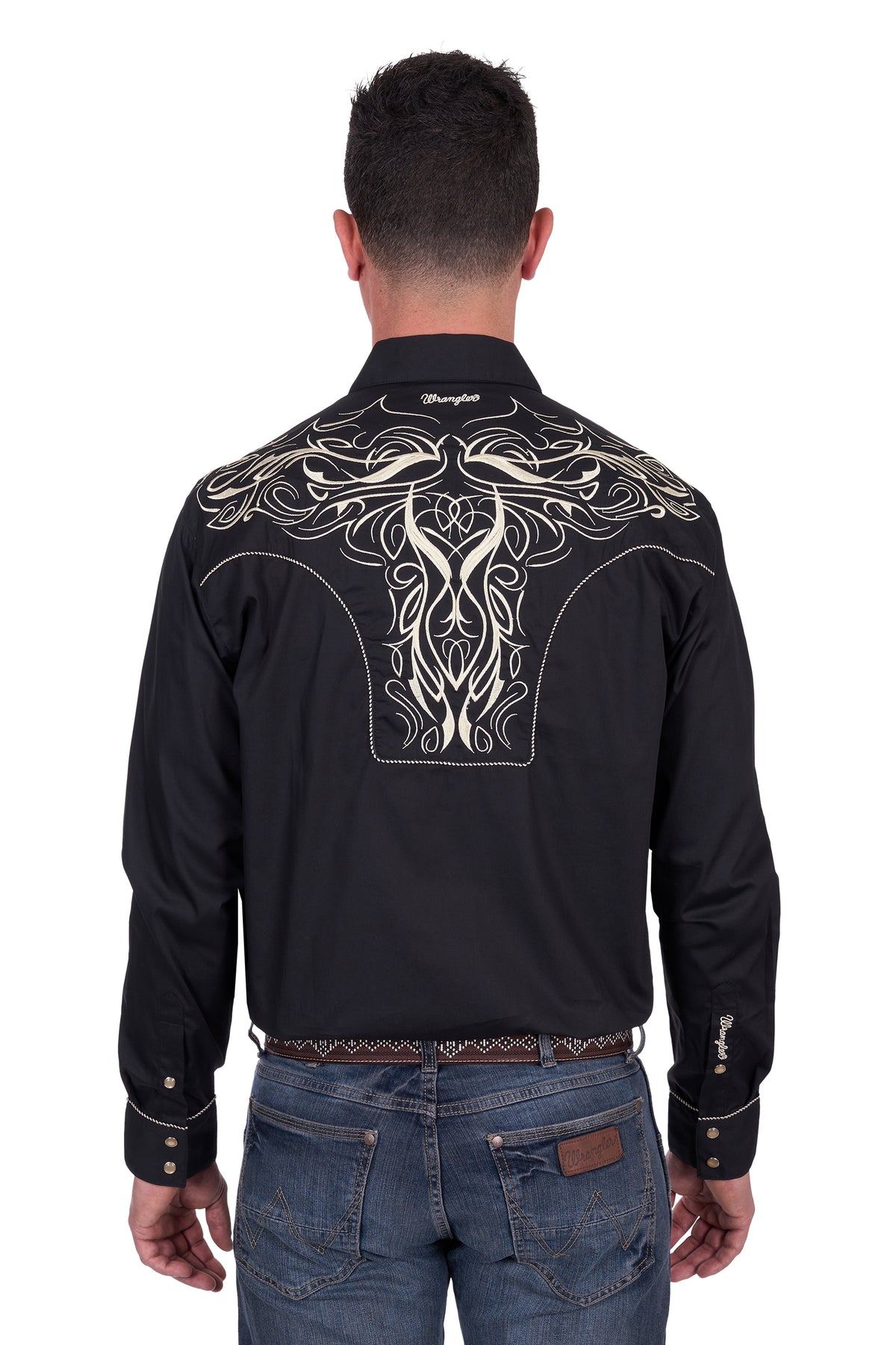 Wrangler Men's Carlos Embroidered L/S Western Shirt. Man wearing a black embroidered shirt with intricate designs on the back, standing against a white background.