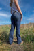Wrangler Women's Mae Jane Jean. Person wearing blue jeans standing in a grassy field with a blue sky.