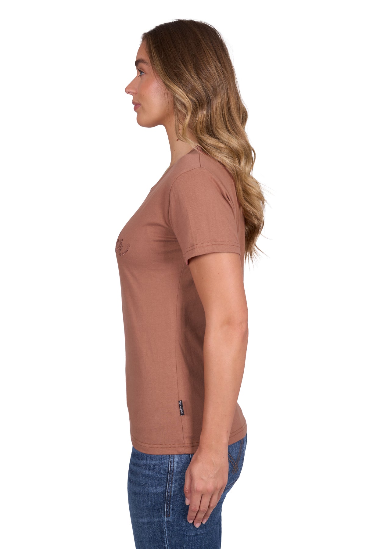 Wrangler Women's Texas S/S T-Shirt. Woman wearing a brown t-shirt and blue jeans on a white background