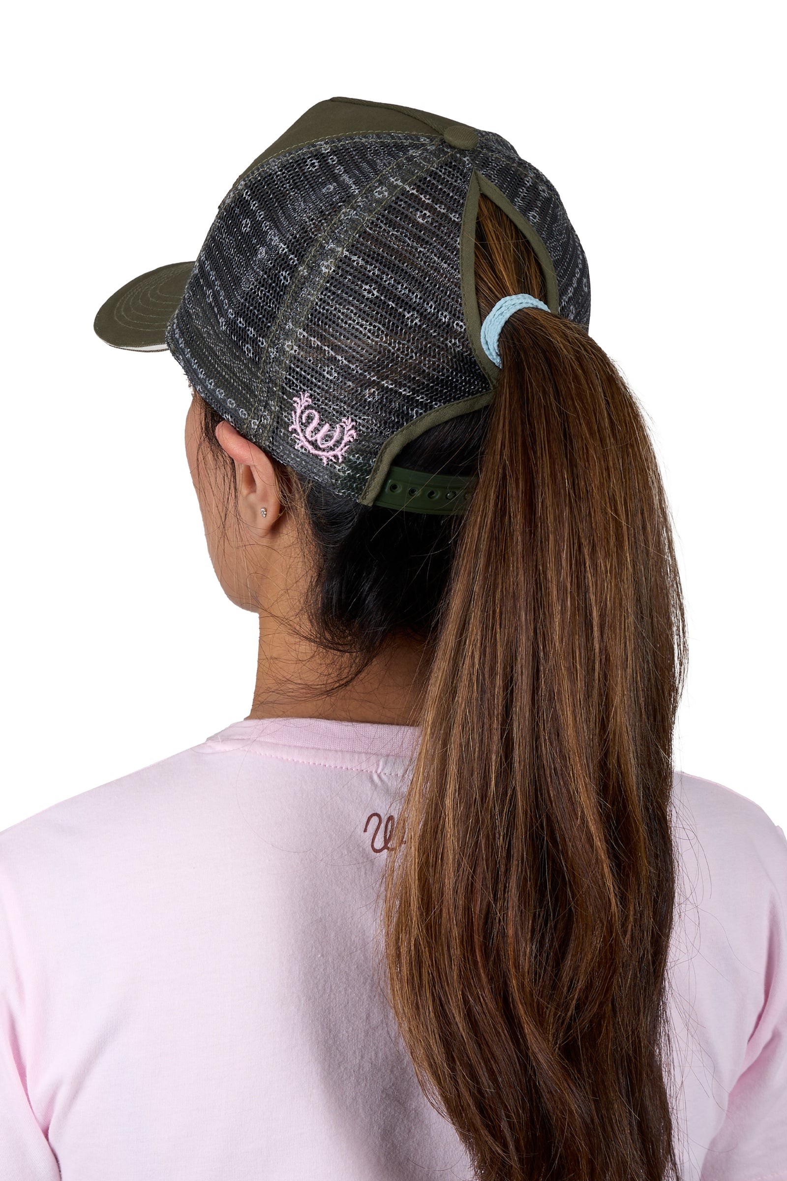 Wrangler Women's Piper HP Ponytail Trucker Cap. Person wearing a cap and pink shirt with a brand logo, on a white background