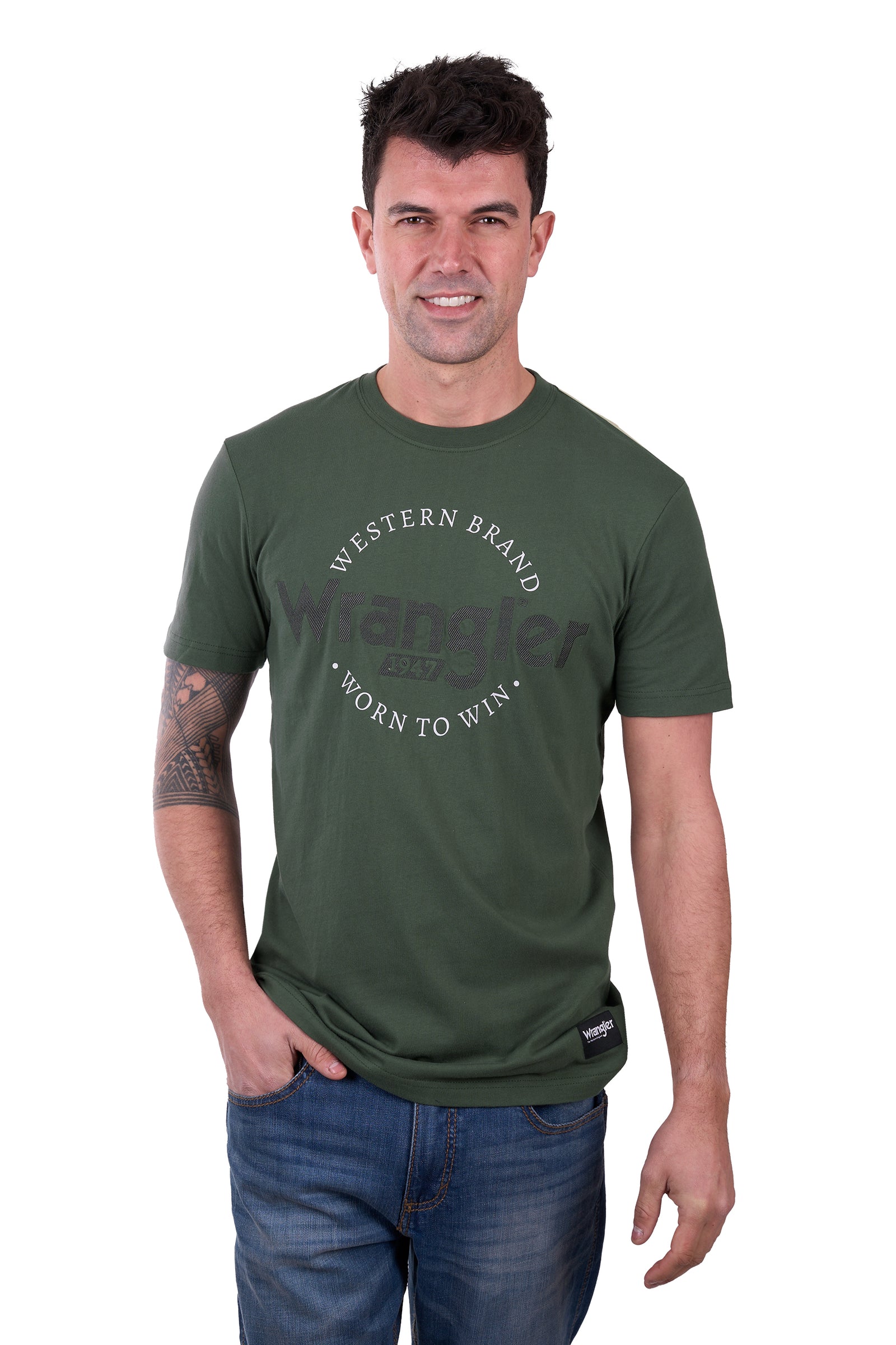 A man wearing a green short-sleeved Wrangler t-shirt with text on it, paired with blue jeans.