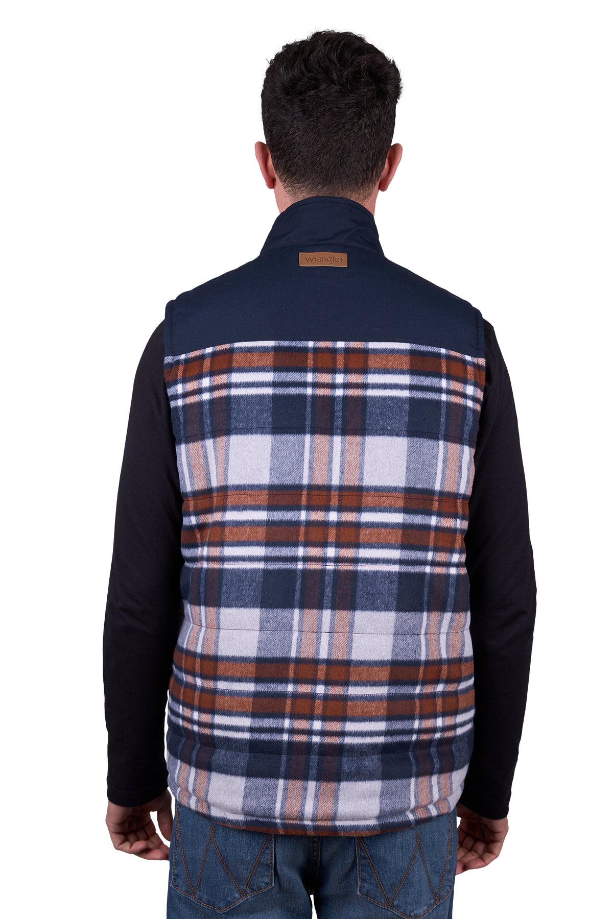A man wearing a Wrangler Men's Koda Reversible Vest in navy and beige colors, paired with a black shirt and blue jeans.