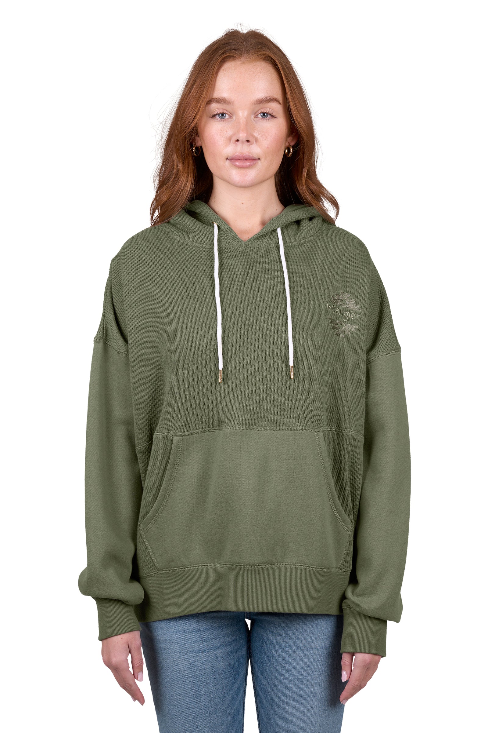 A woman wearing a green Wrangler Women's Lisa Hoodie with a front kangaroo pocket, hood with drawcord, and the Wrangler logo on the chest.