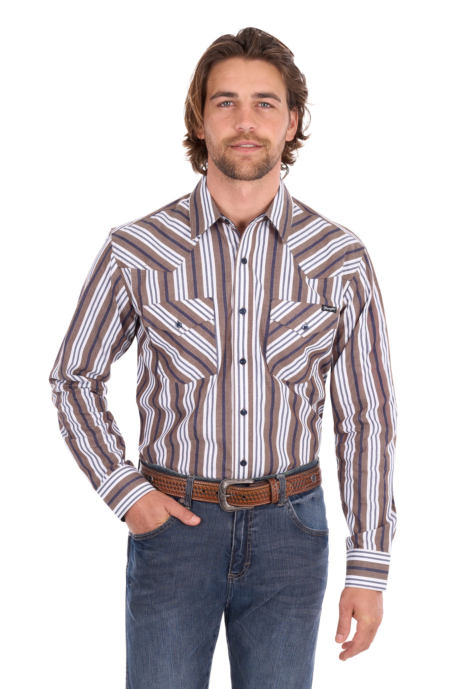 A man wearing a brown, white, and gray striped western-style button-down shirt with a brown leather belt and blue jeans, standing against a plain white background.