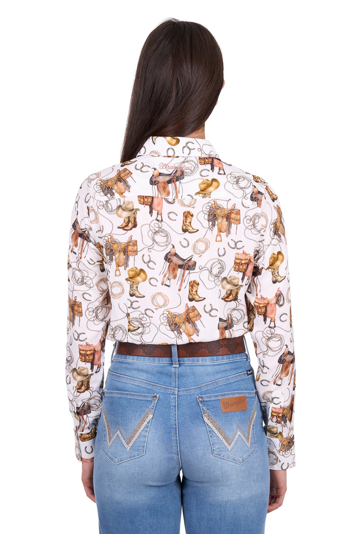 Woman wearing a patterned shirt with cowboy-themed designs and blue jeans on a white background