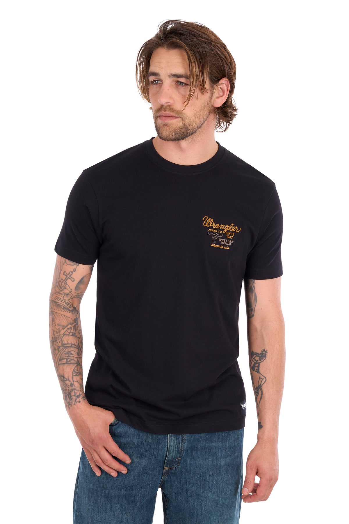 A man wearing a black crew-neck t-shirt with a yellow 'Wanderers' graphic on the left chest, paired with blue jeans, photographed against a solid white background.