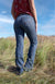 Wrangler Women's Luna Willow Trouser. Person wearing blue jeans standing in a grassy field with a blue sky.