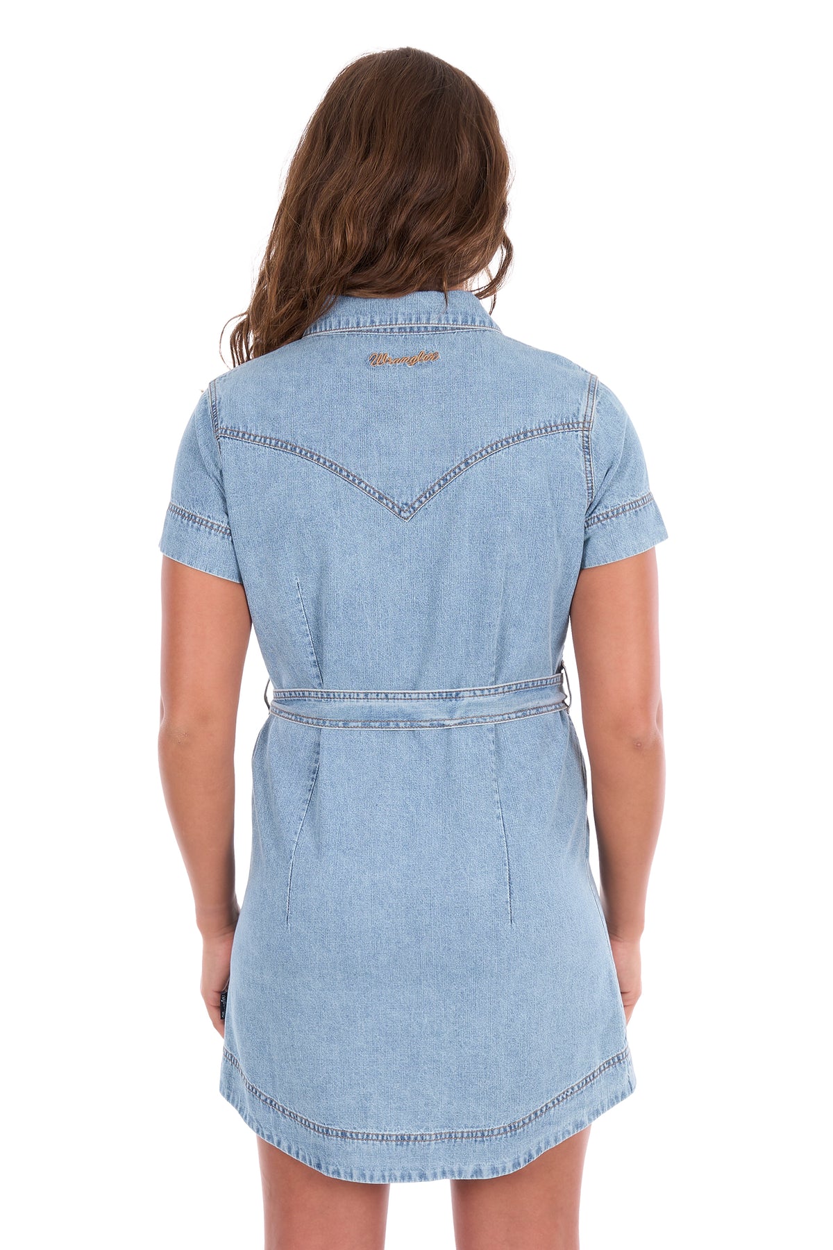 A woman viewed from the back wearing a light blue denim shirt dress with a matching waist belt, set against a plain white background.