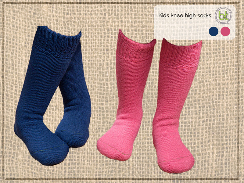 Bamboo Kids 8-10 Xthick Knee High Socks. Two pairs of kids knee-high socks, one blue and one pink, on a textured beige background.