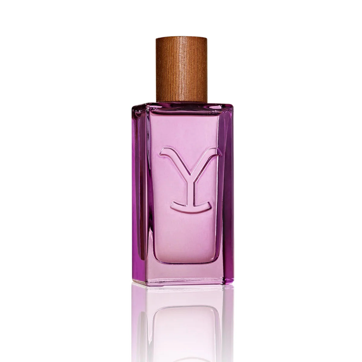 A rectangular glass perfume bottle with a translucent pink-purple liquid, featuring an embossed 'Y' logo on the front and a light brown wooden cap, set against a solid white background with a soft reflection below.