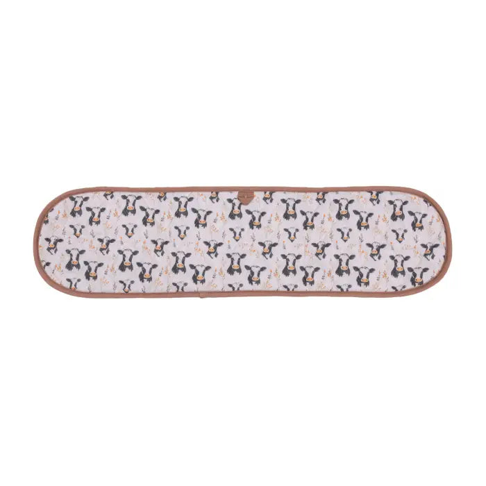 A long, narrow quilted blanket with a cow print pattern on a white background, finished with a brown border.