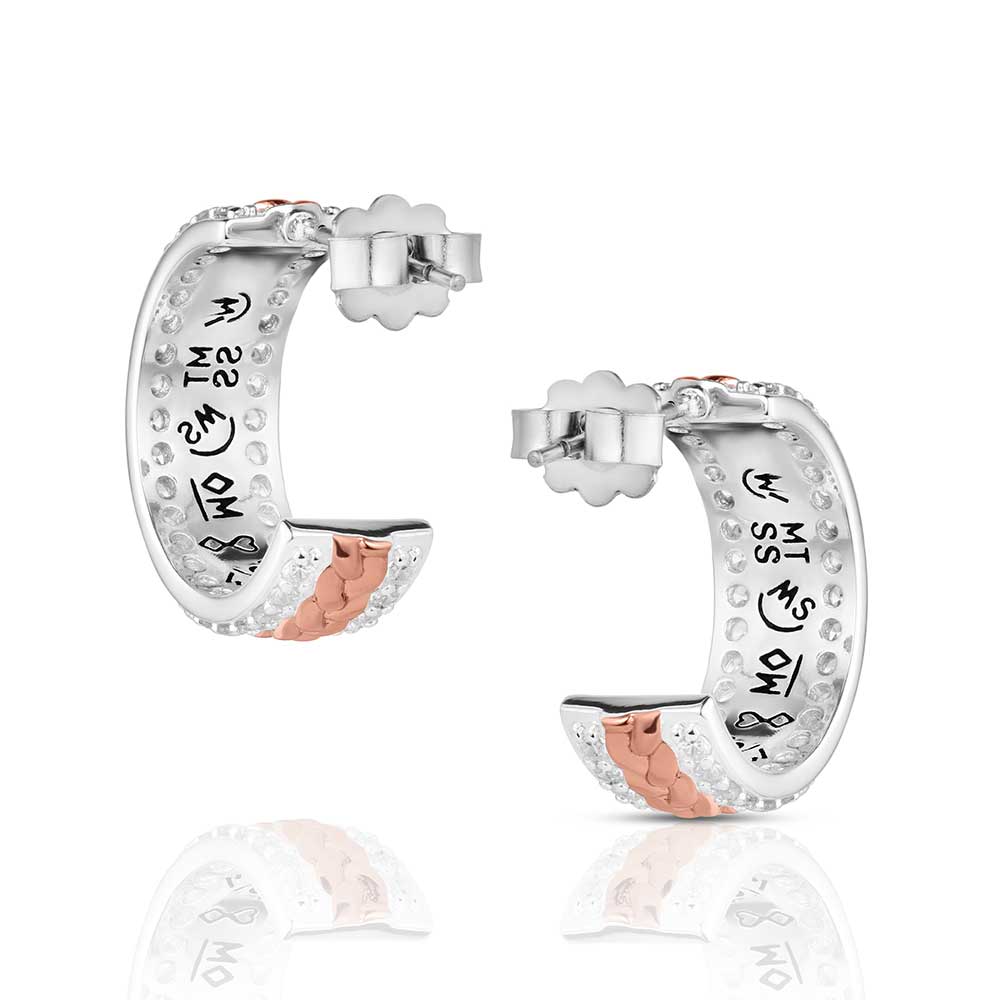 Silver and rose gold hoop earrings with engraved designs on a white background