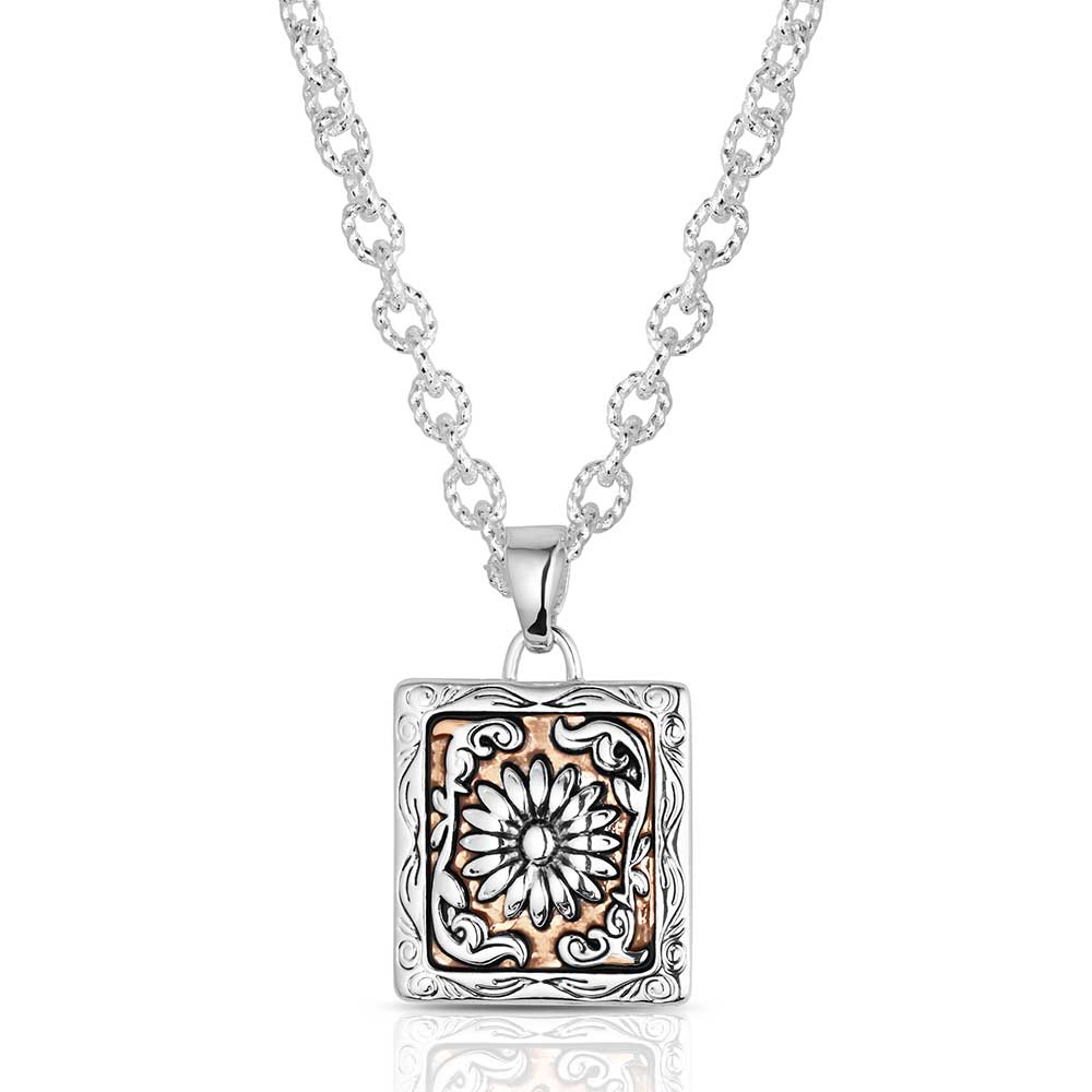 Silver necklace with a square pendant featuring floral design on a white background