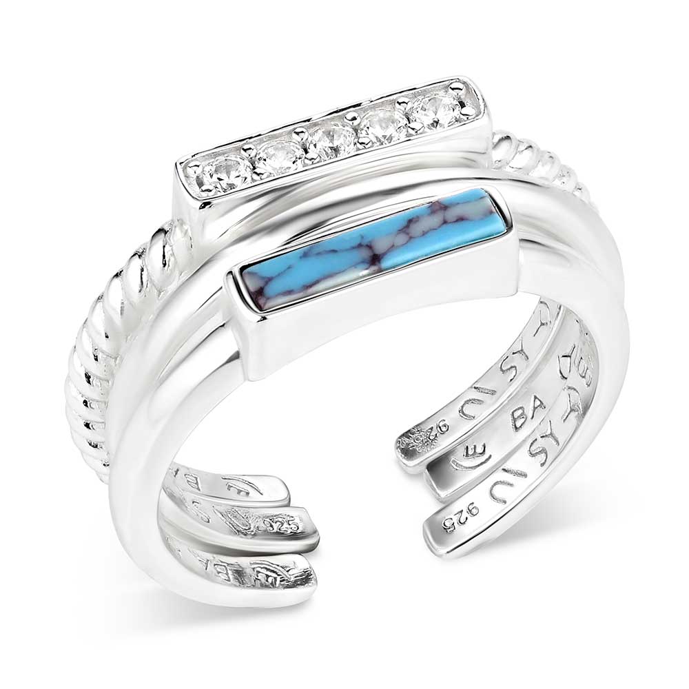 Silver ring with turquoise inlay and clear gemstones on a white background
