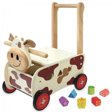 I'm Toy Walk And Ride Cow Sorter. Wooden toy cow push cart with colorful blocks on a white background