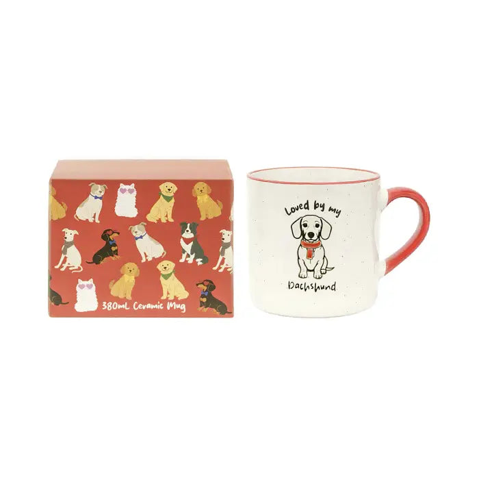 A ceramic mug with a red handle and red rim, printed with a dog illustration and the words 'Loved by my Doghandler,' shown next to its red gift box decorated with multiple dog illustrations.