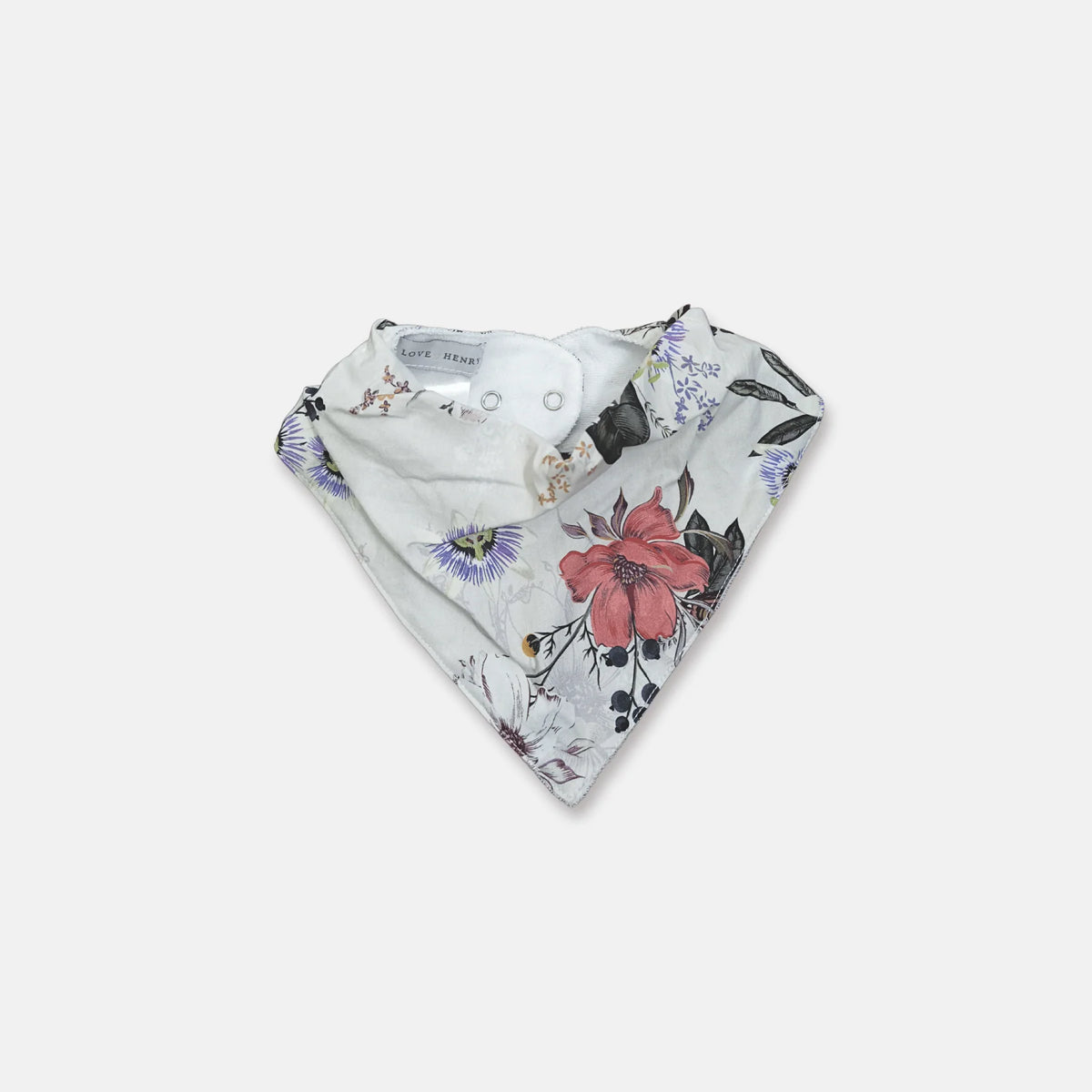 A triangular reusable baby bandana bib with a white background and a floral print featuring a prominent pink flower, purple passionflowers, and dark green leaves. The bib has snap closures at the top and a visible 'BIB BANDANA' brand label inside.